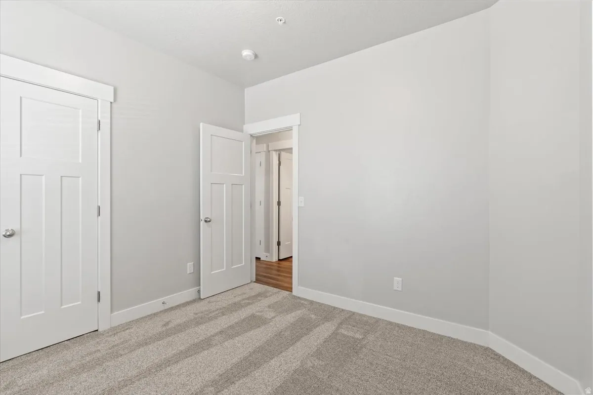 Unfurnished bedroom featuring carpet flooring and baseboards