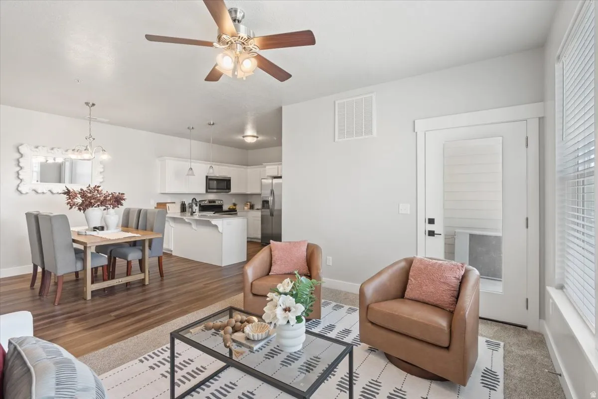 Living area featuring a ceiling fan and baseboards