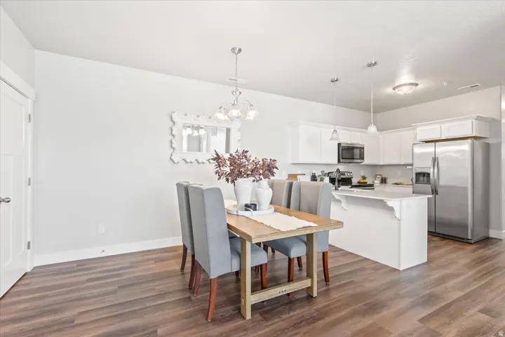 Dining area with a chandelier and dark wood finished floors