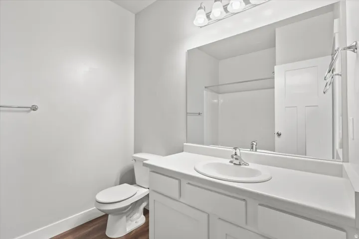 Bathroom with vanity, dark wood-style flooring, and a shower