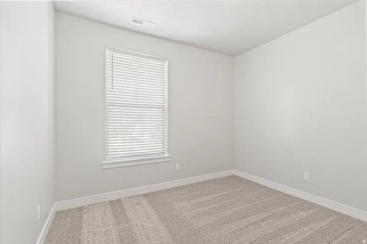 Unfurnished room with light colored carpet and baseboards