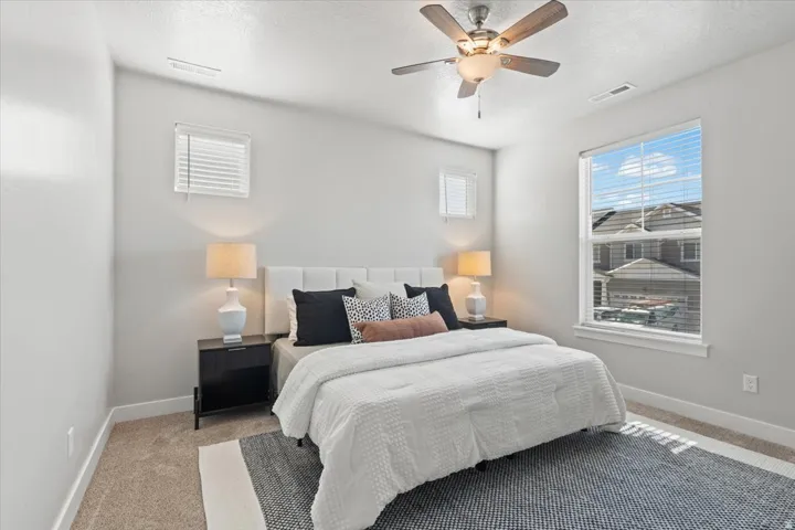 Bedroom featuring carpet, a textured ceiling, and a ceiling fan