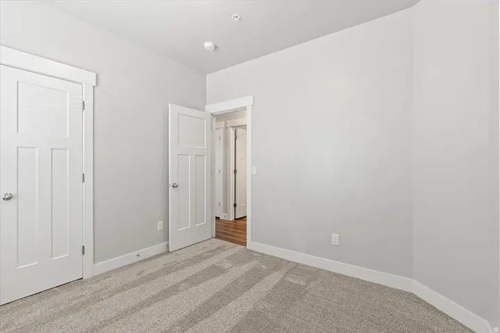 Unfurnished bedroom featuring carpet flooring and baseboards