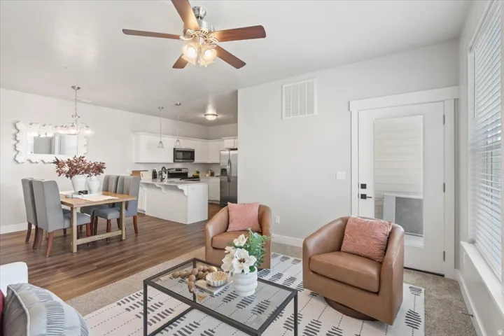 Living area featuring a ceiling fan and baseboards