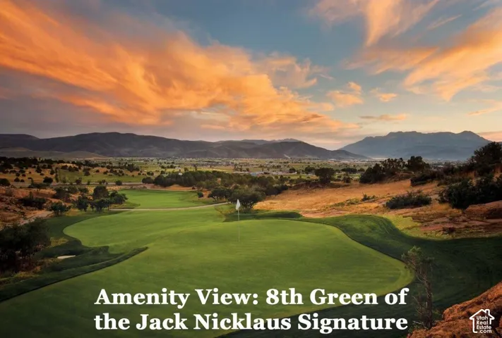 Expansive golf course green with surrounding natural landscaping and distant mountains