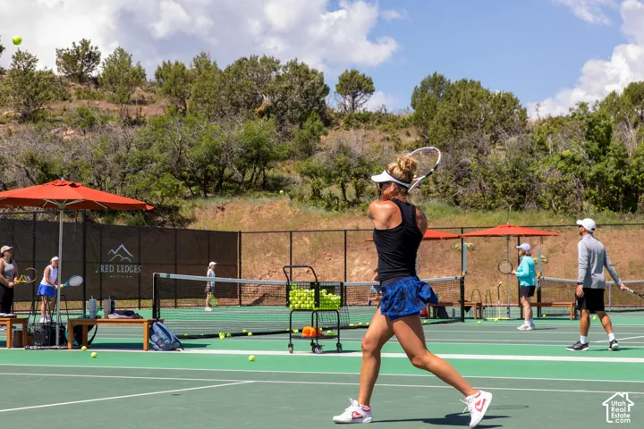 Tennis court with a green playing surface and black fencing