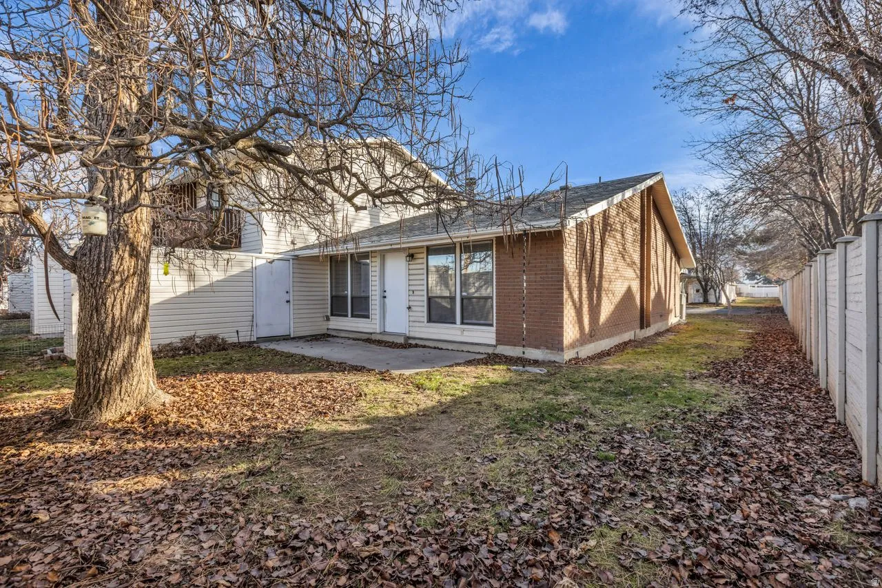 Rear view of property featuring a patio and brick siding