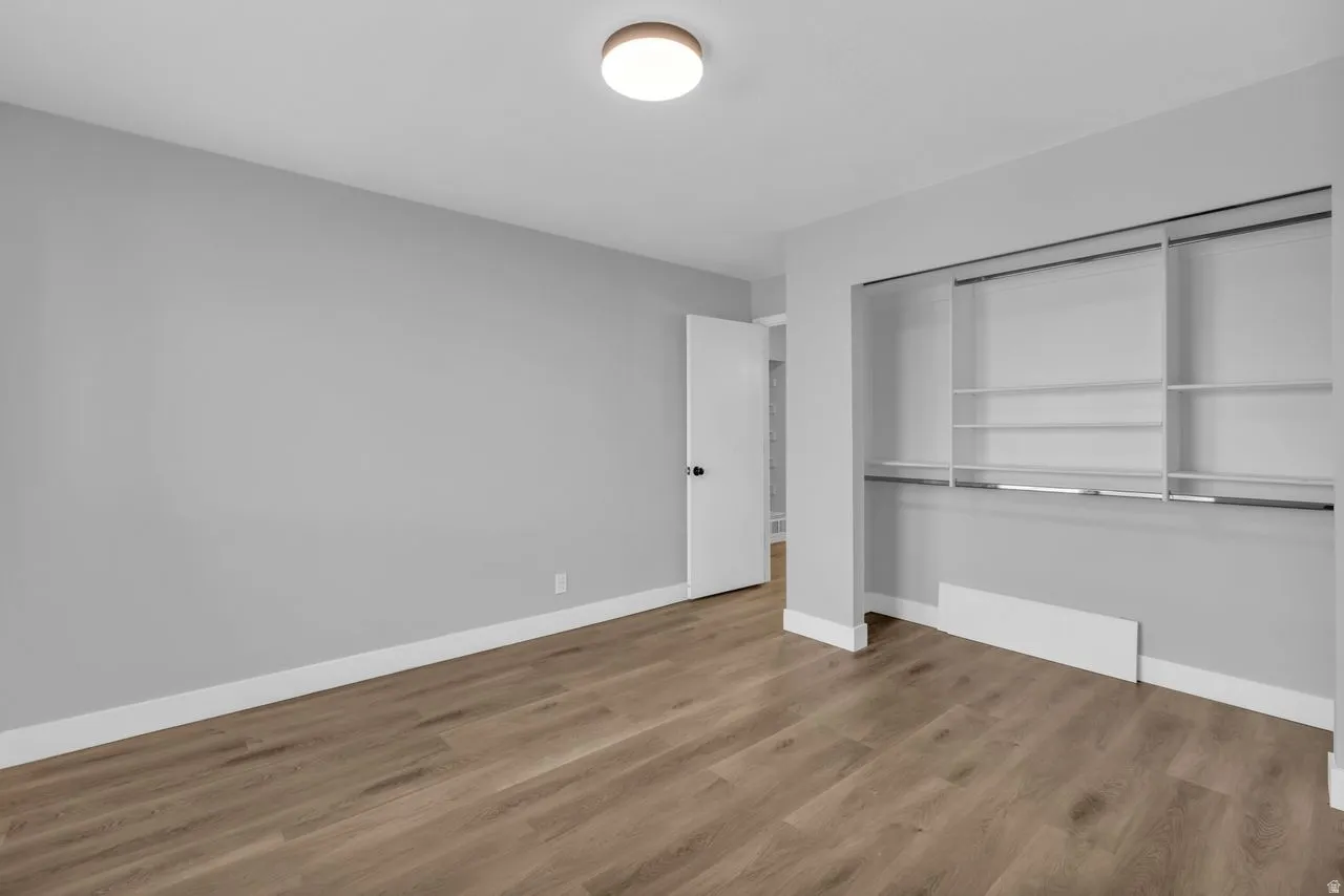 Unfurnished bedroom featuring light wood finished floors and a closet