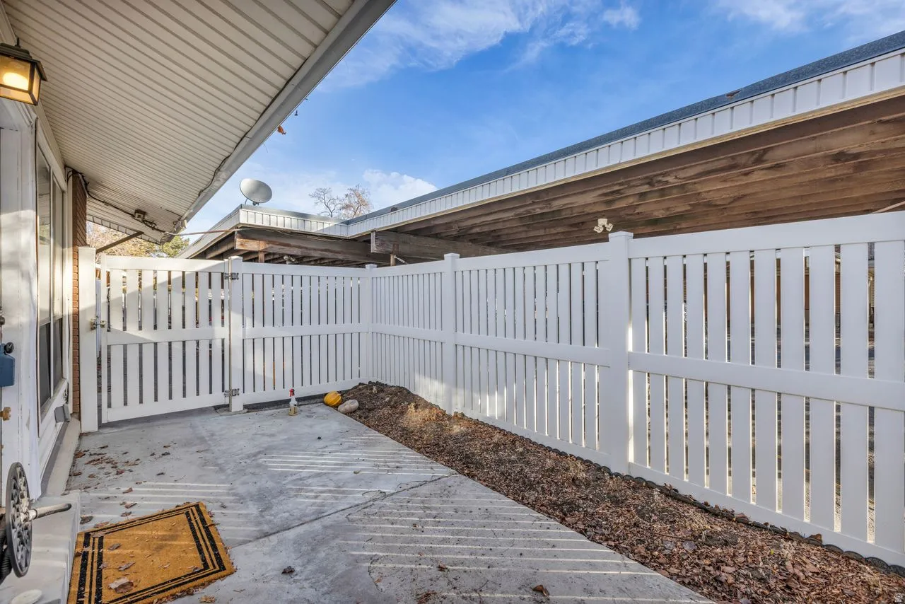 Fenced backyard featuring a gate and a wooden deck