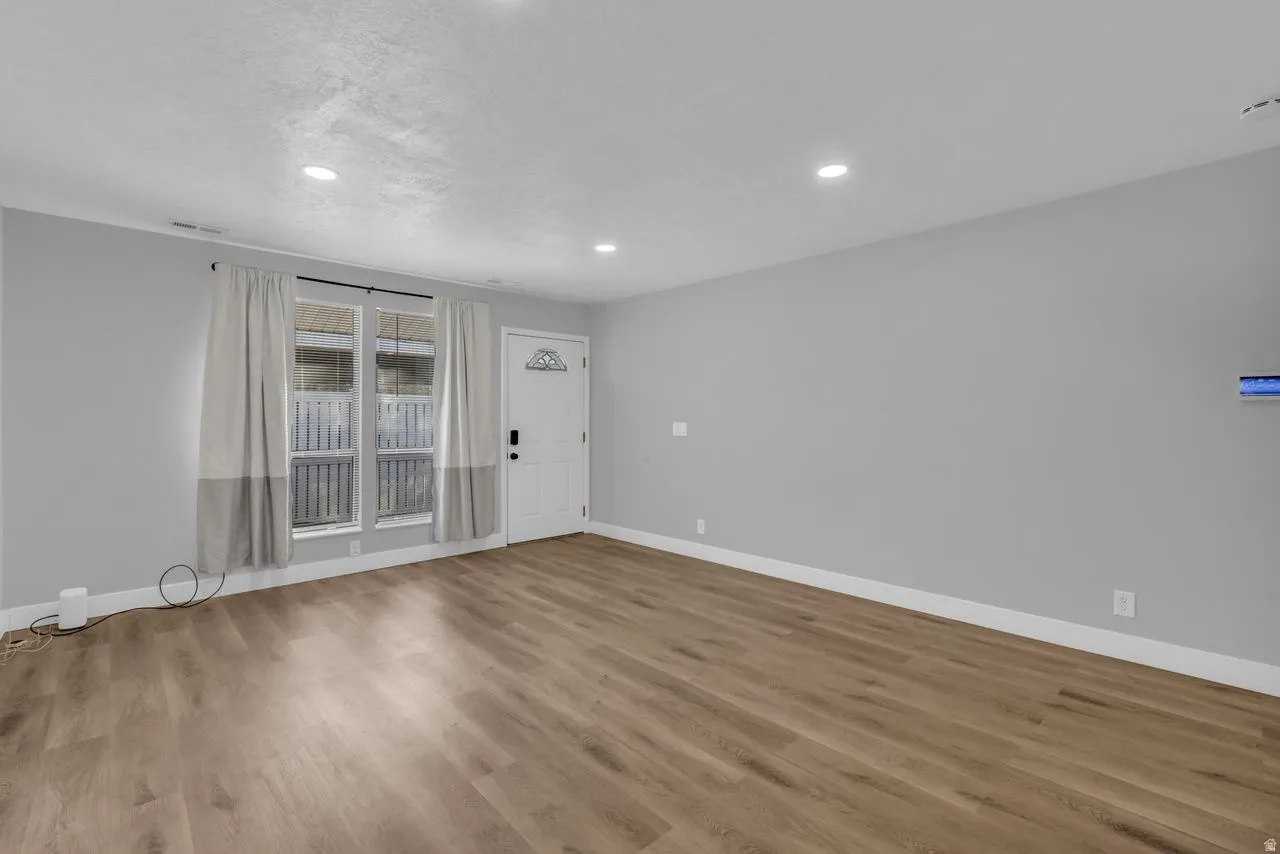 Spare room with wood finished floors and recessed lighting