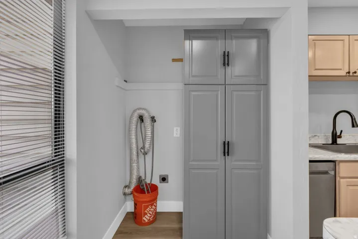Interior space with wood finished floors, light wood finish cabinetry, light stone countertops, and stainless steel dishwasher