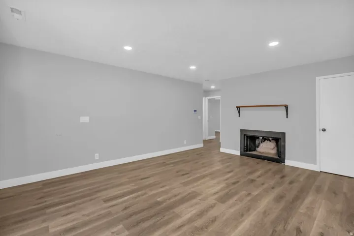 Unfurnished living room with light wood-style flooring, a fireplace, and recessed lighting