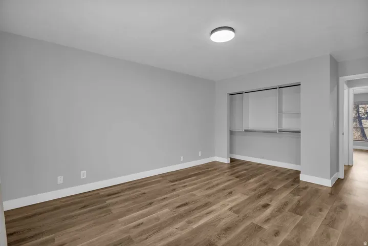 Unfurnished bedroom featuring wood finished floors and a closet
