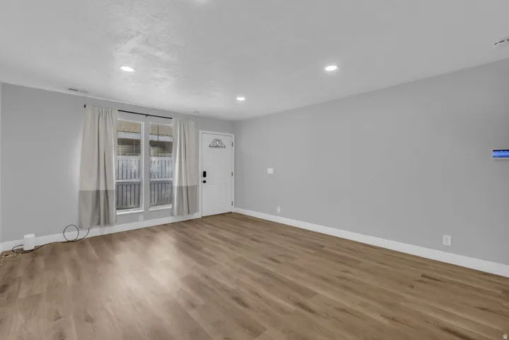Spare room with wood finished floors and recessed lighting