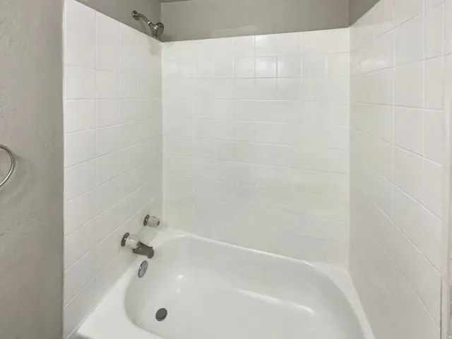 White tile shower surround with a built-in tub