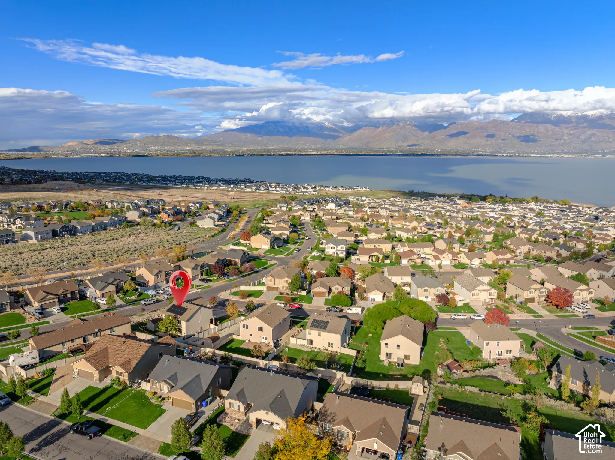 Aerial perspective of residential neighborhood featuring expansive lake scenery and mountain range backdrop