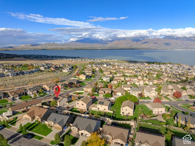 Aerial perspective of residential neighborhood featuring expansive lake scenery and mountain range backdrop