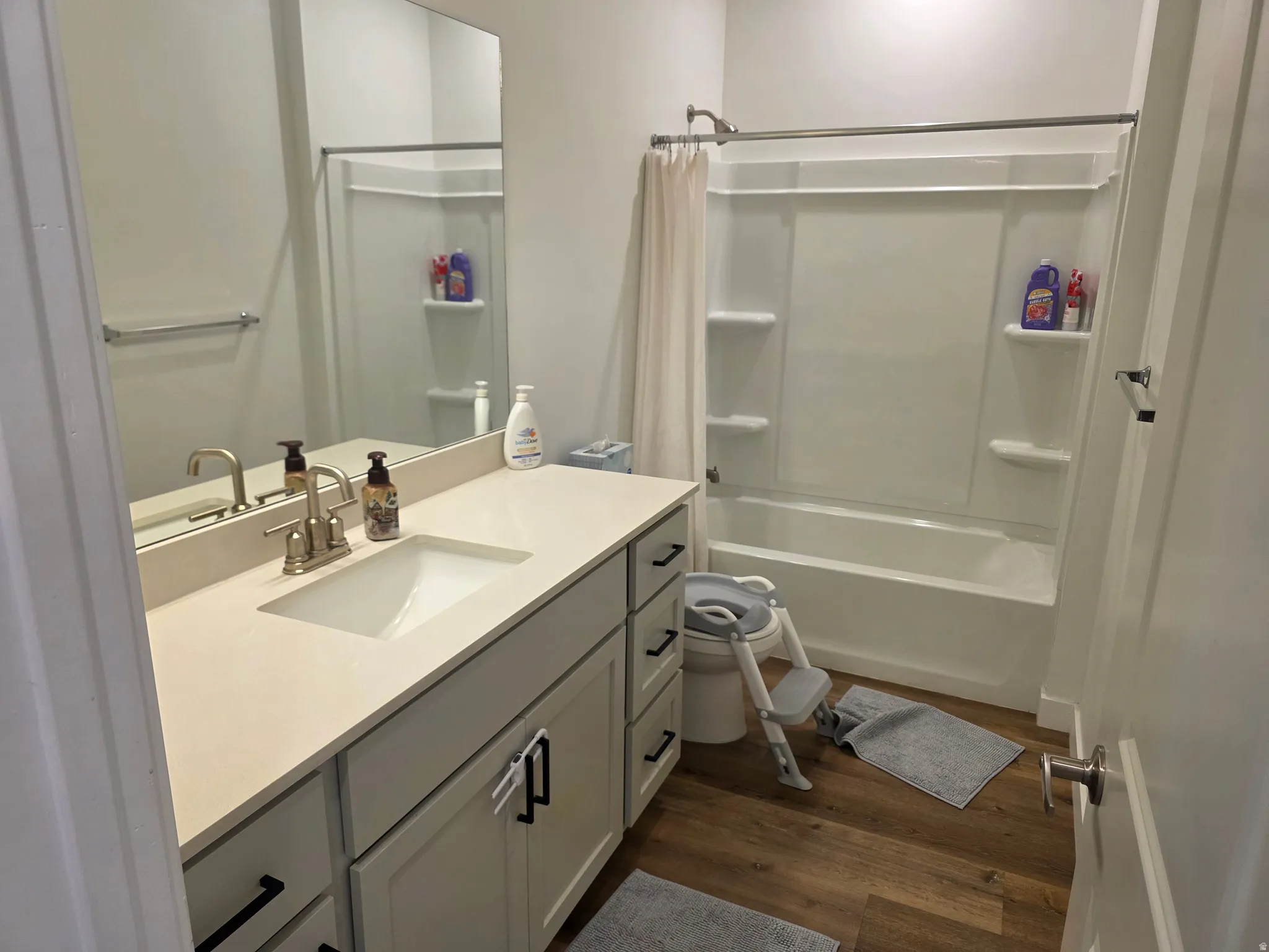 Full second bathroom with vanity, shower / tub combo with curtain, and dark wood finished floors