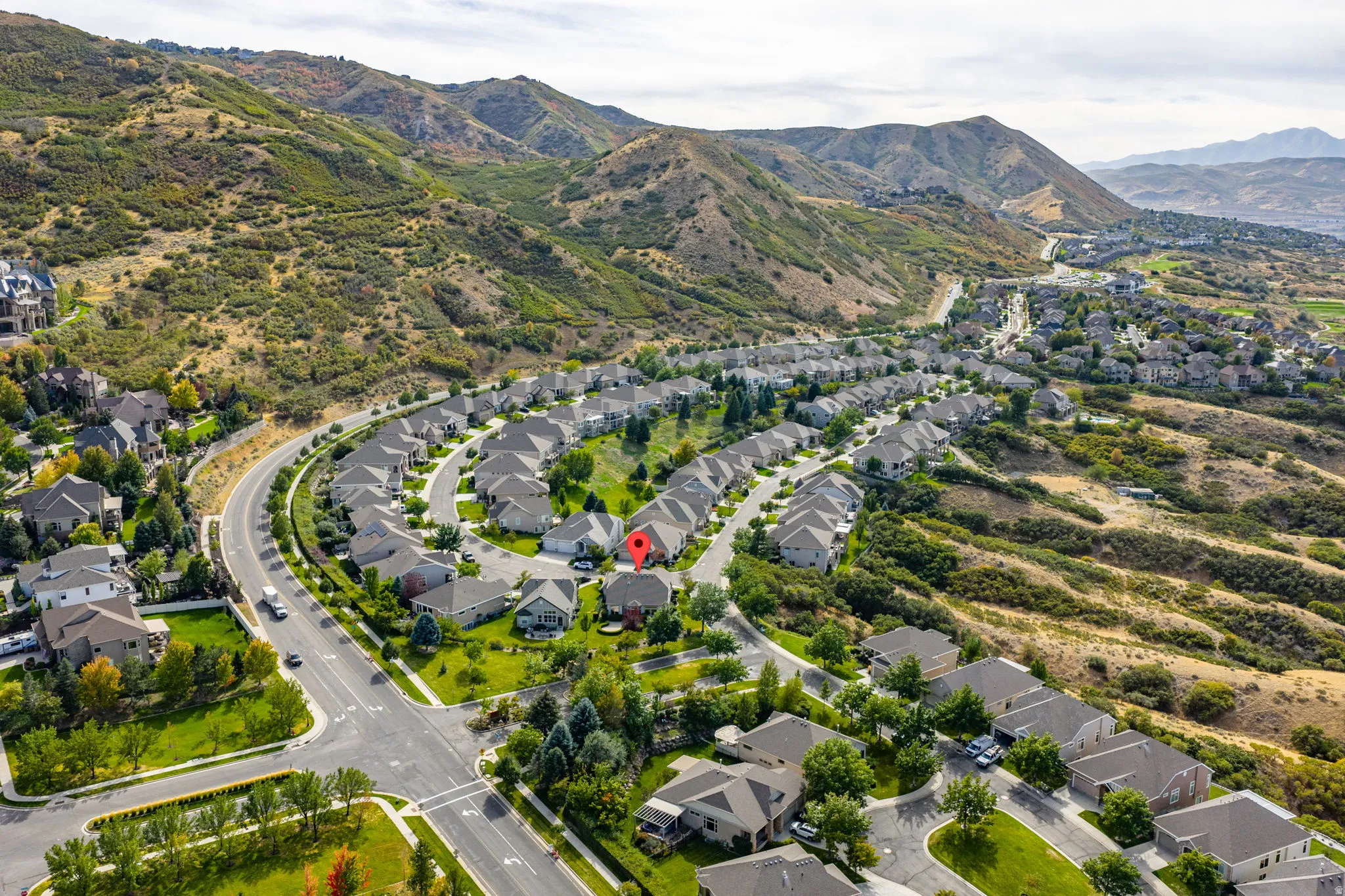 Aerial view of property's location with a mountain backdrop and nearby suburban area
