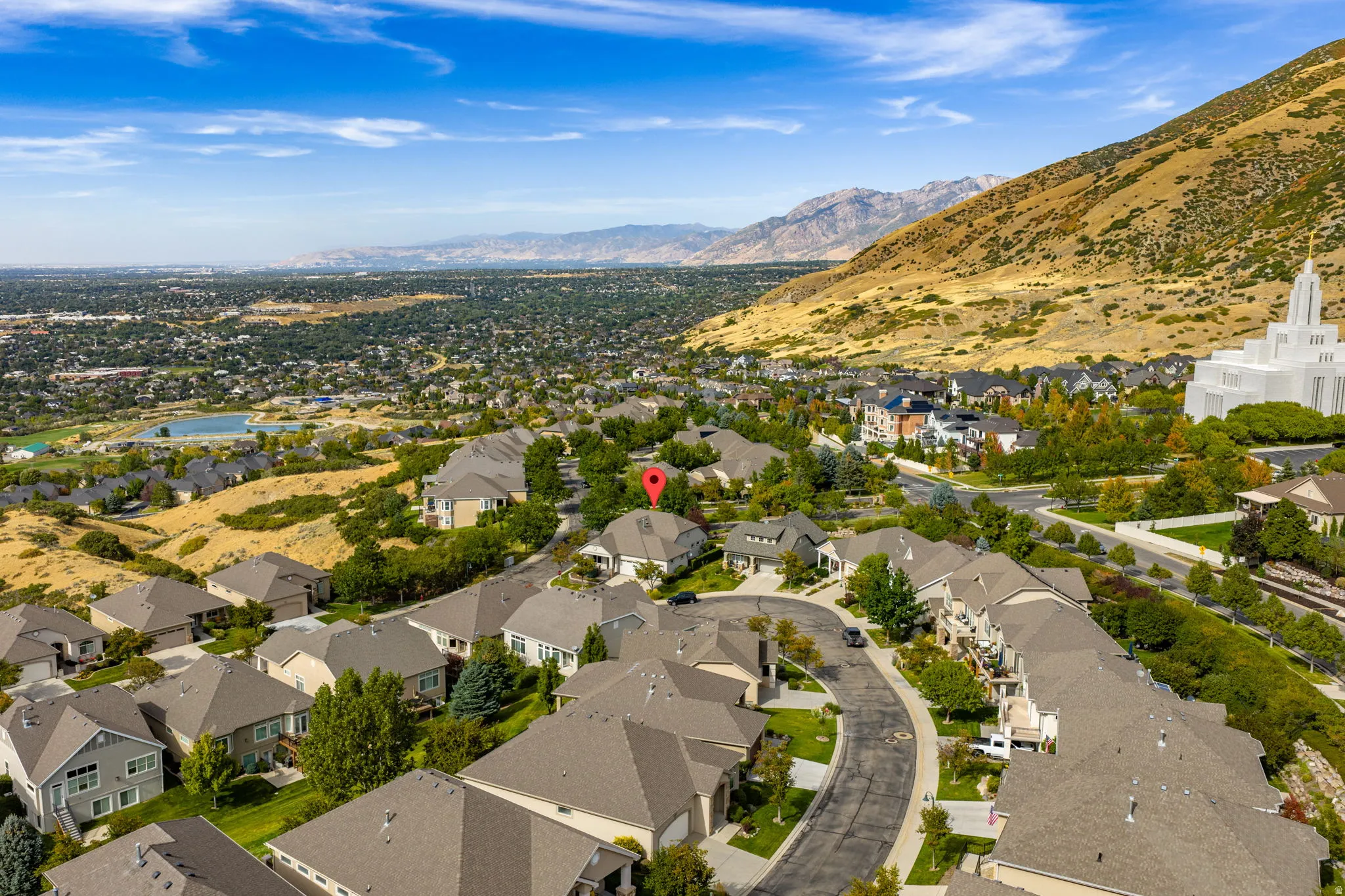 Aerial view of property and surrounding area with nearby suburban area and a mountainous background