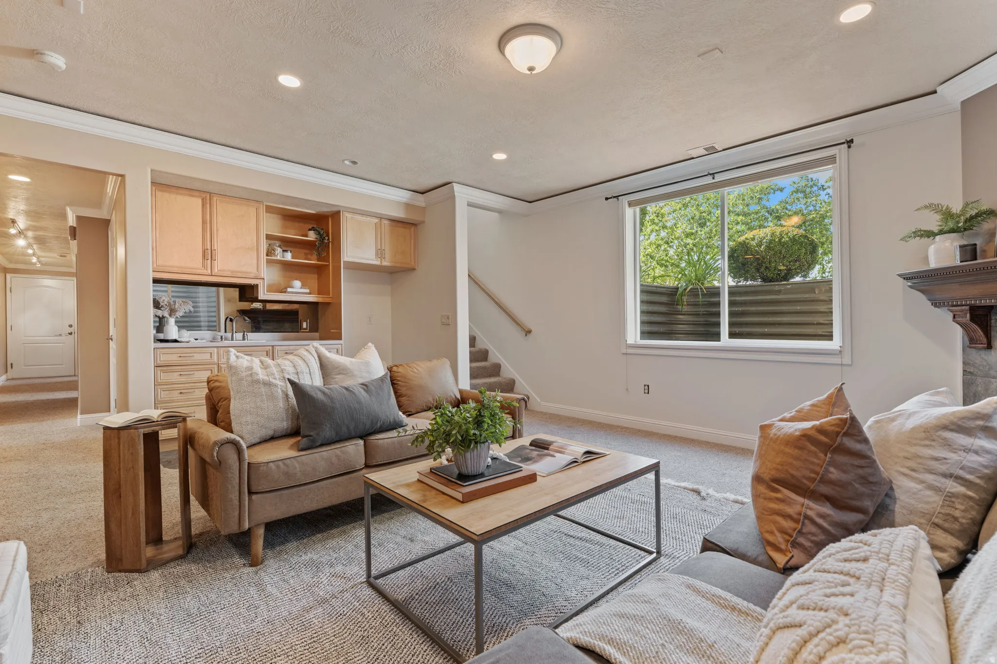 Living room with light carpet, stairs, a textured ceiling, recessed lighting, and ornamental molding