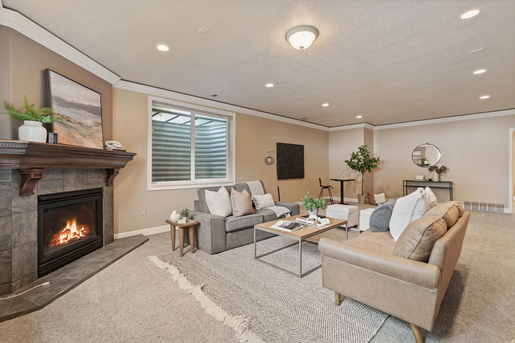 Carpeted living room featuring a fireplace, recessed lighting, and ornamental molding
