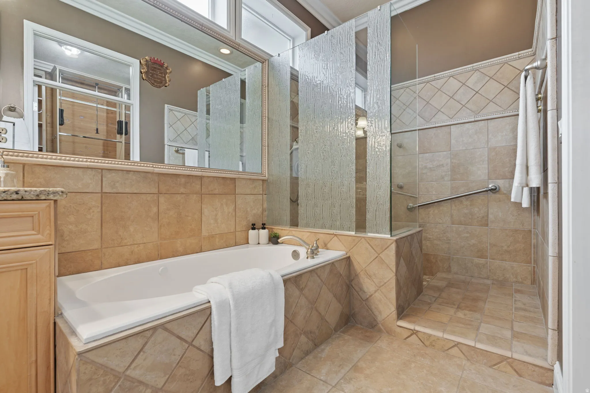 Bathroom featuring a walk in shower, a bath, vanity, and crown molding