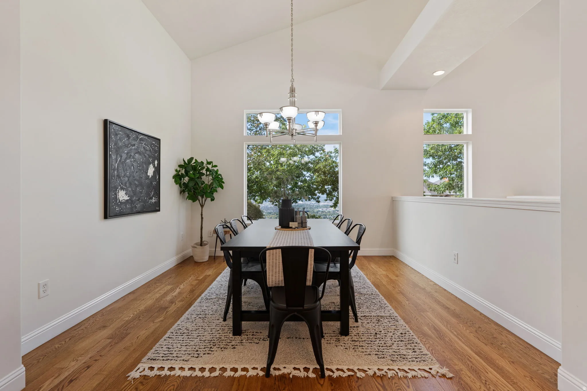 Dining space with high vaulted ceiling, a chandelier, light wood-style flooring, and recessed lighting