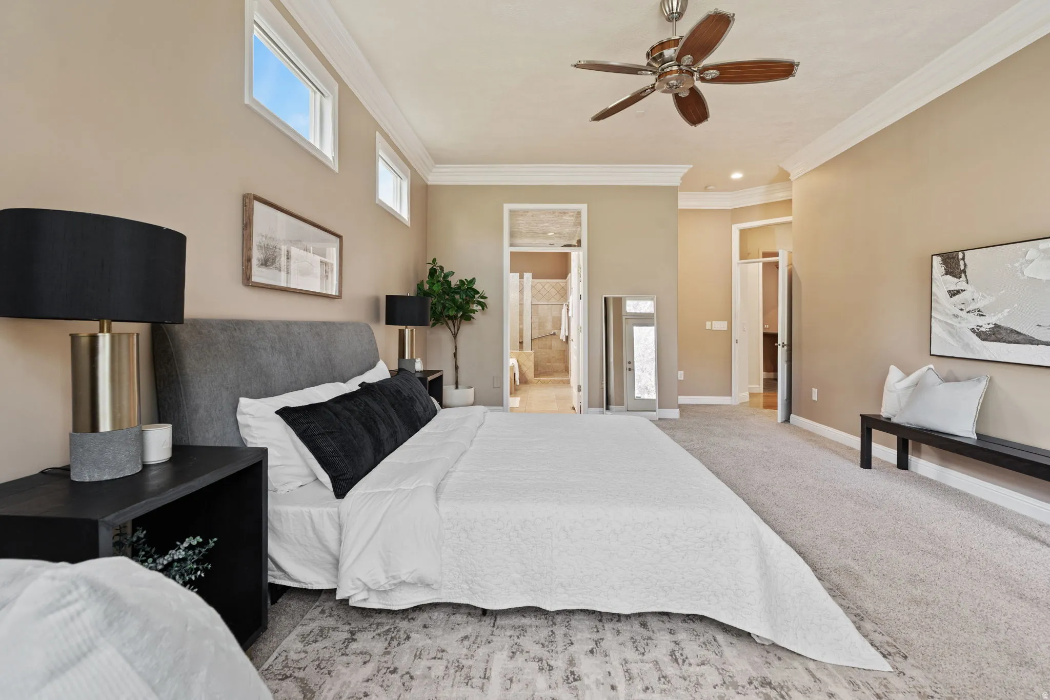 Master bedroom with crown molding, ensuite bathroom, carpet, and ceiling fan