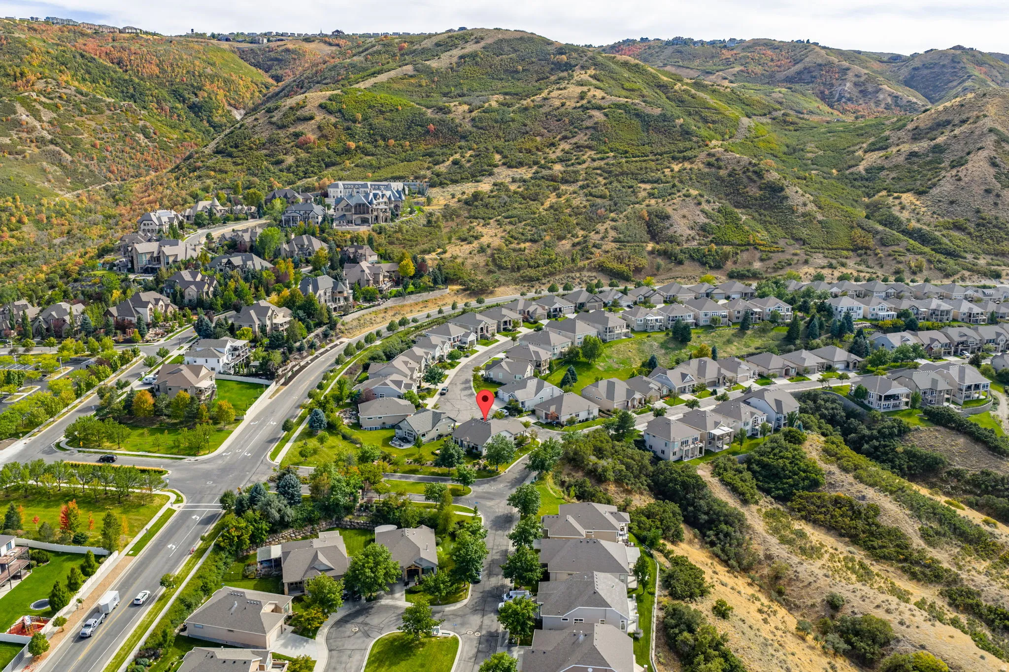 Aerial overview of property's location with nearby suburban area and a mountain backdrop