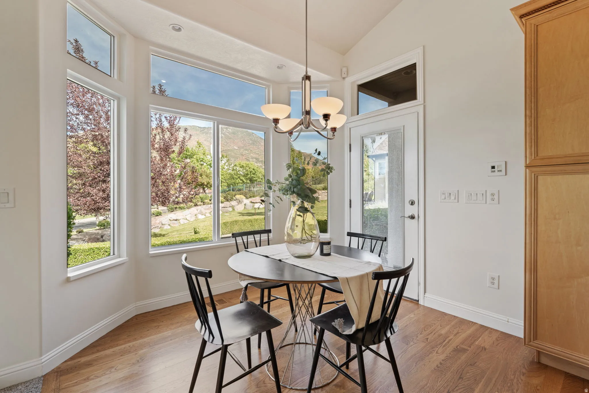 Dining space featuring light wood-style flooring, a chandelier, and lofted ceiling