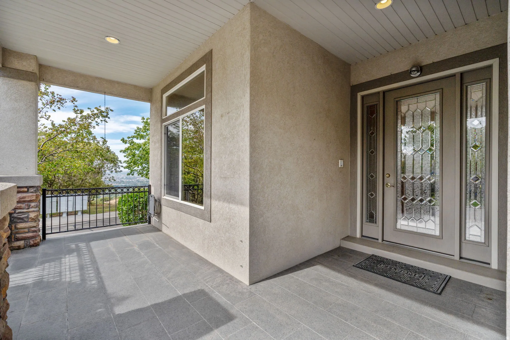 Property entrance featuring stucco siding and a patio