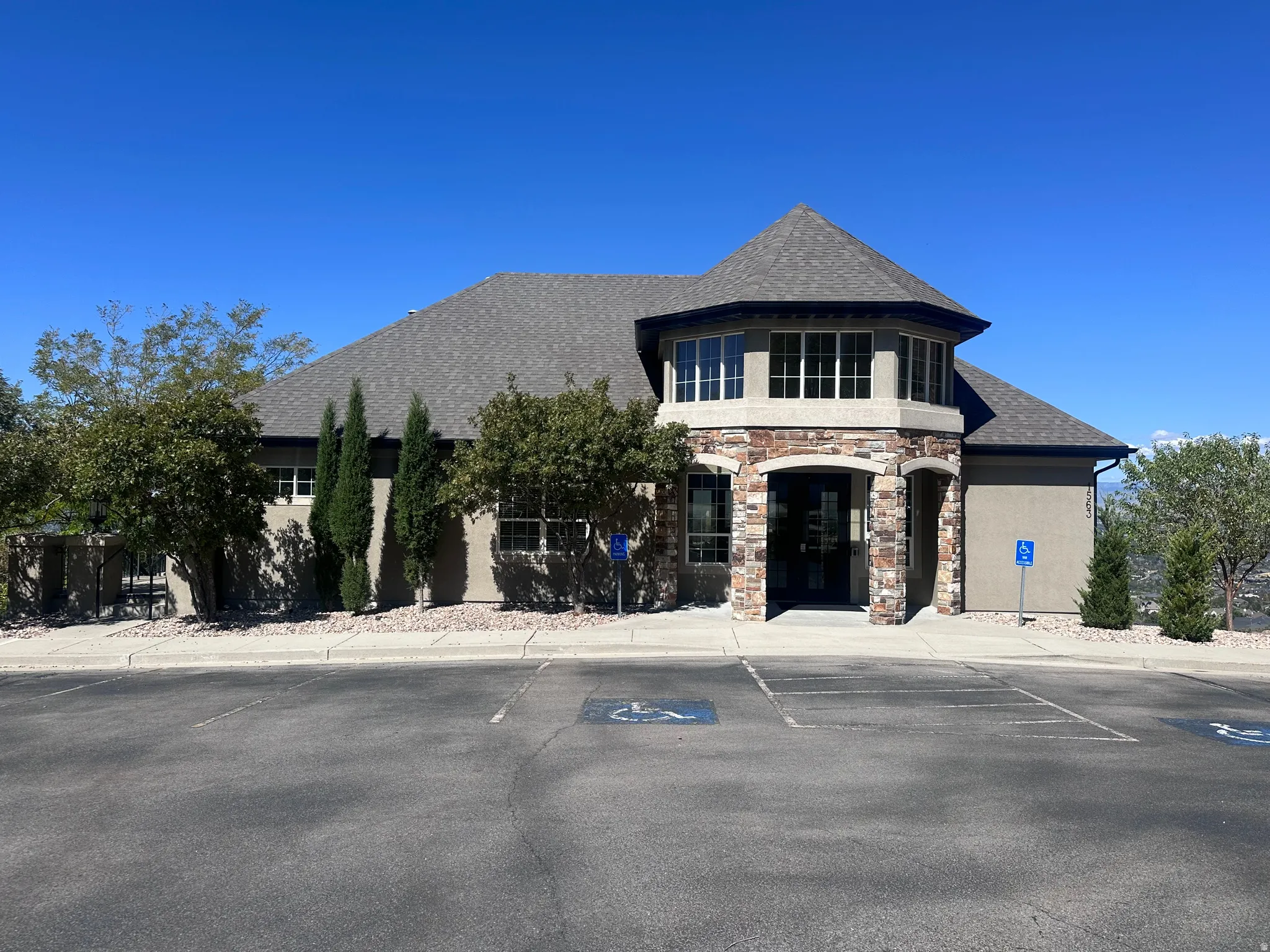 View of clubhouse building exterior featuring uncovered parking