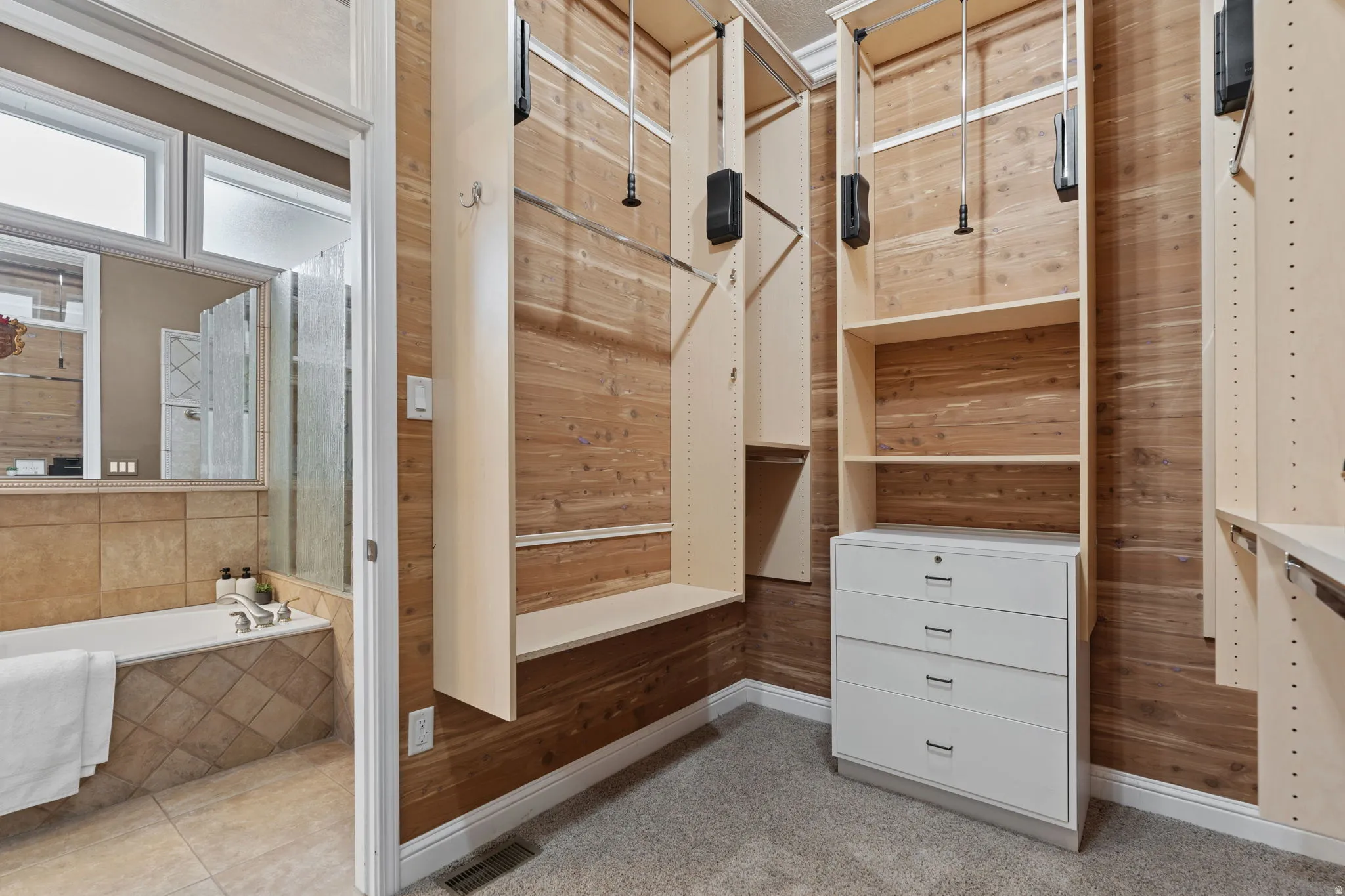 Spacious custom cedar closet with light colored carpet