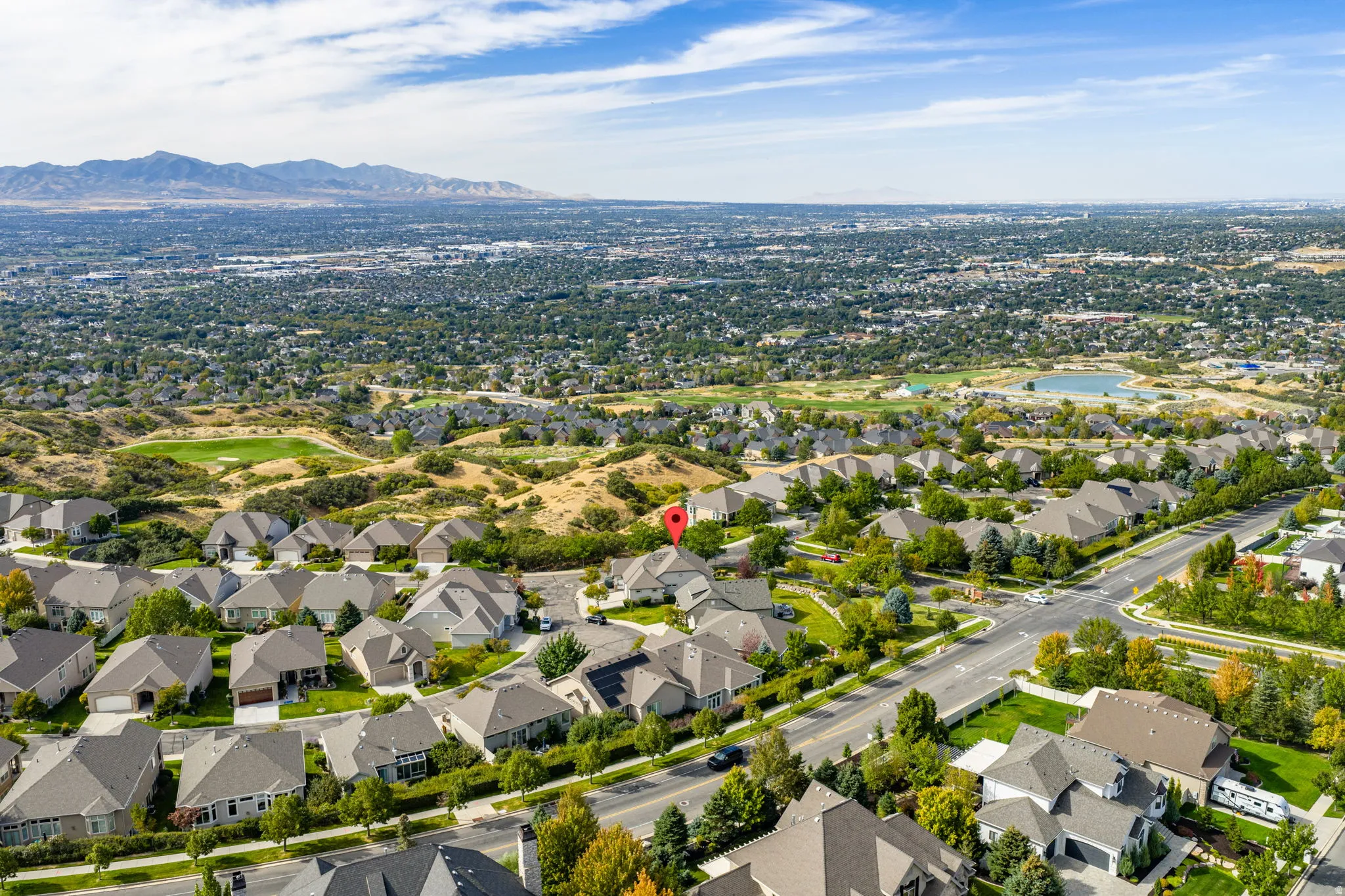 Aerial view of property and surrounding area with nearby suburban area and a mountainous background