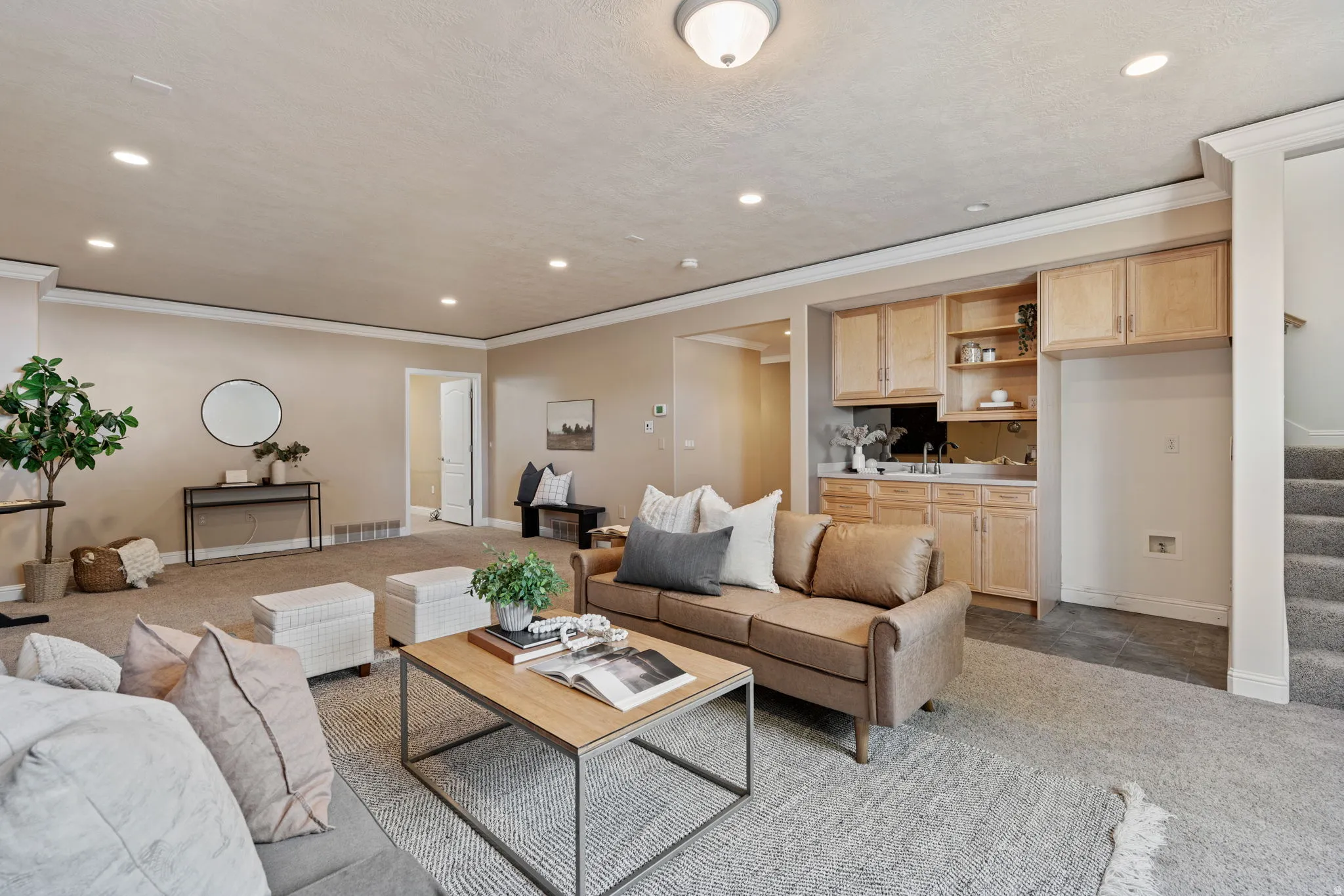 Carpeted living room featuring recessed lighting, stairs, ornamental molding, and a textured ceiling