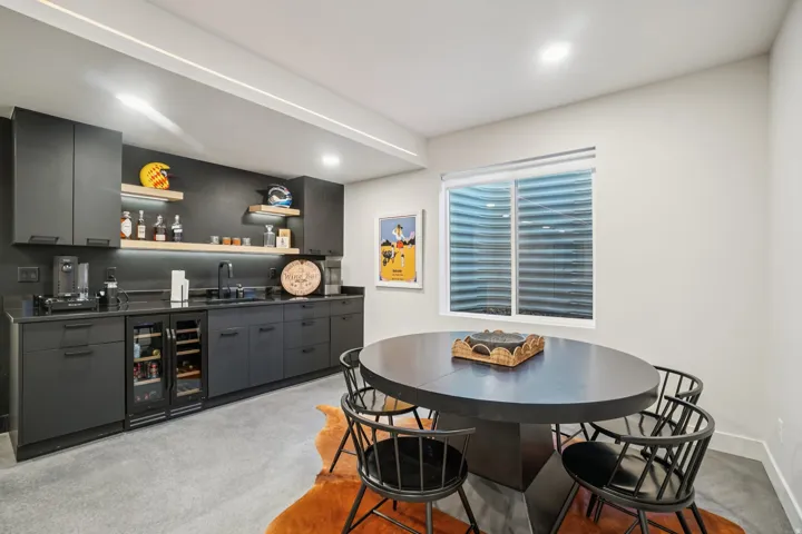 Dining room featuring wine cooler, bar with sink, and concrete floors