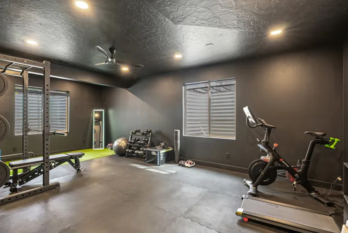 Workout area with rubber floors, recessed lighting, ceiling fan, and a textured ceiling
