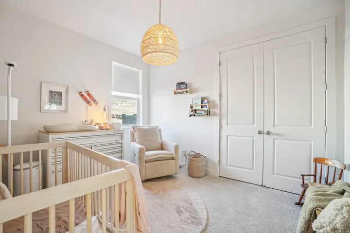 Bedroom with a crib and carpet floors