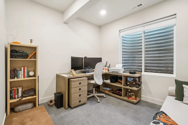 Office area with baseboards and light carpet