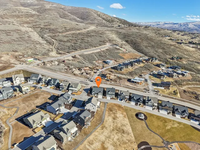 Aerial view of property and surrounding area with nearby suburban area and a mountainous background
