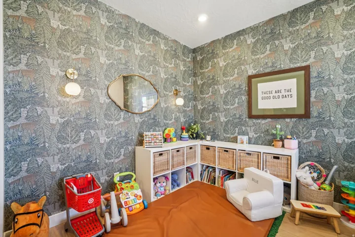 Playroom with wood finished floors, a textured ceiling, and wallpapered walls