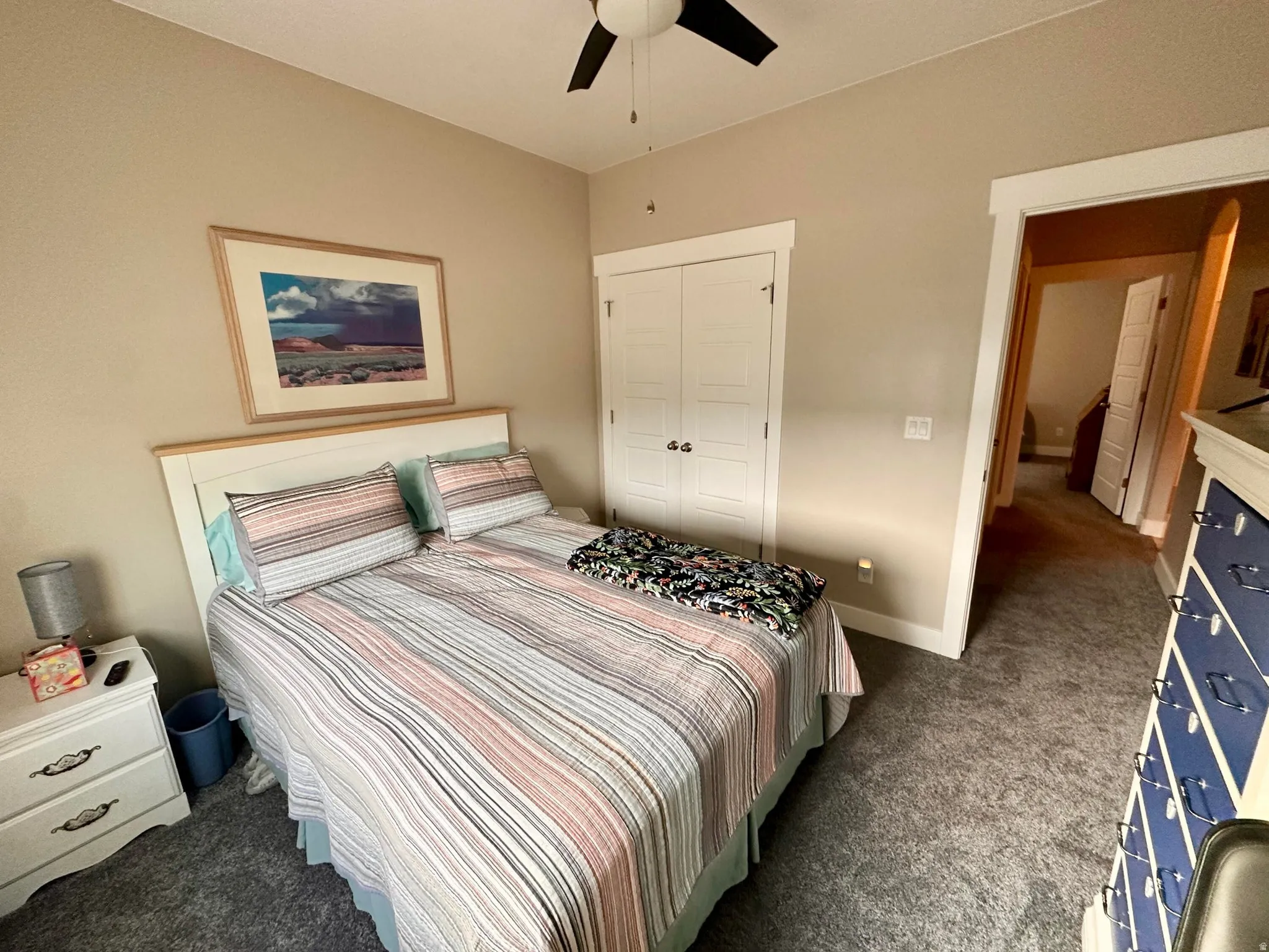 Bedroom featuring dark carpet, a closet, and ceiling fan