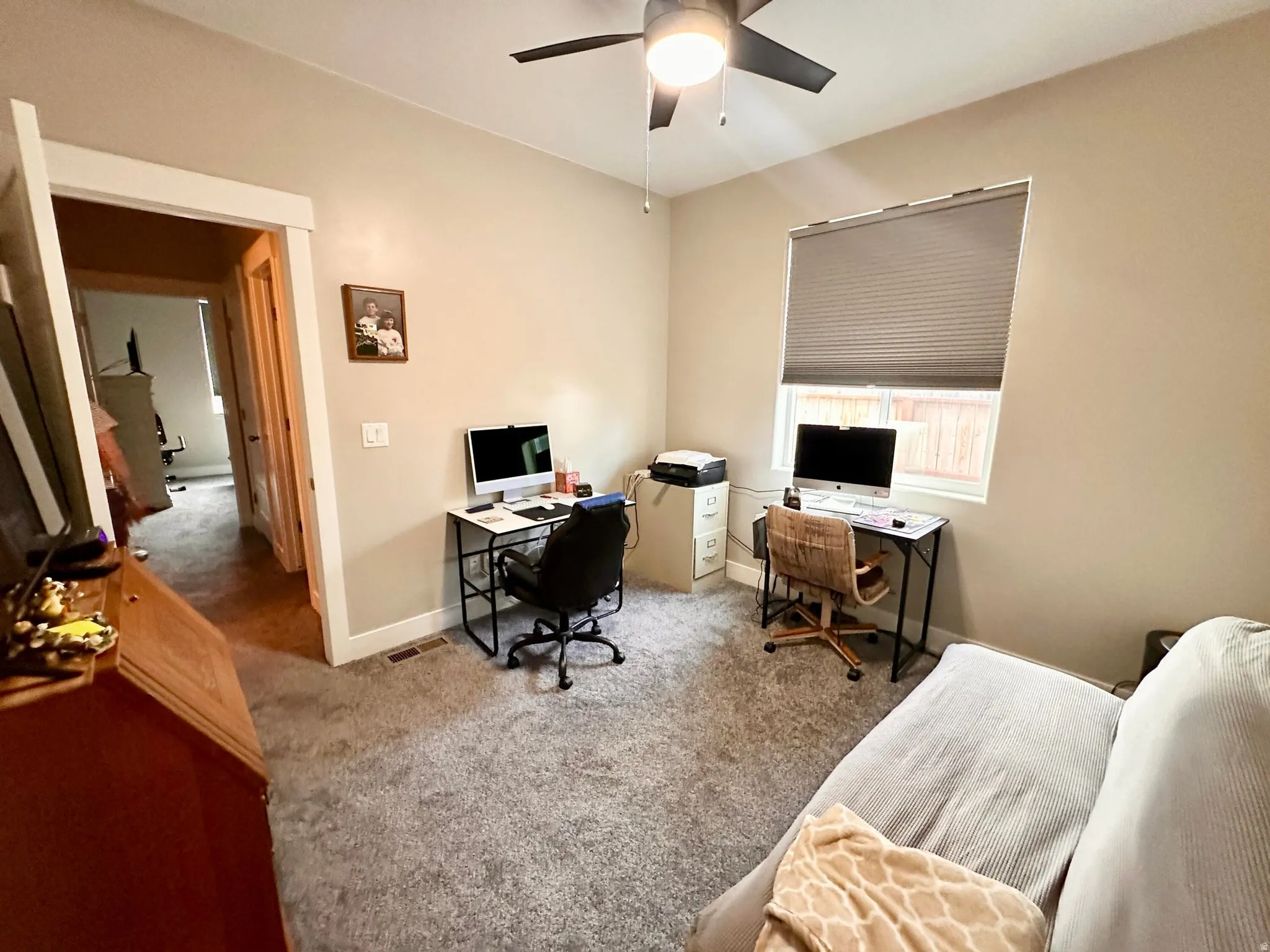 Carpeted office space with baseboards and ceiling fan