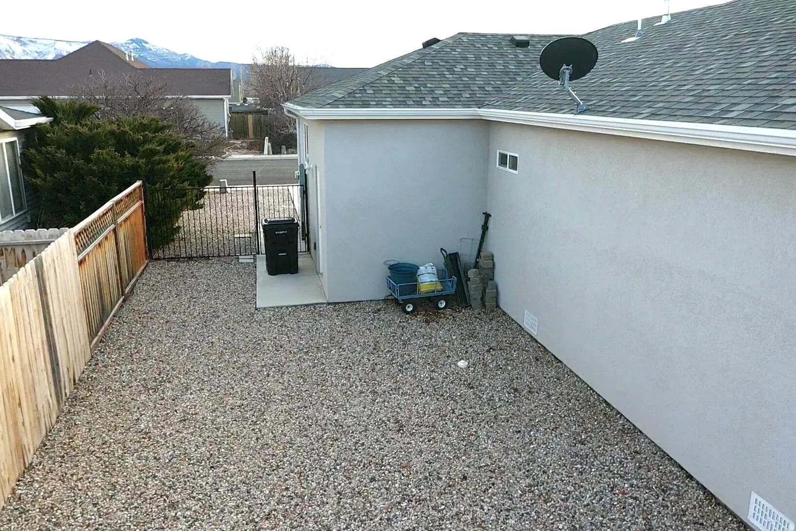 View of property exterior with a fenced backyard, stucco siding, and a shingled roof