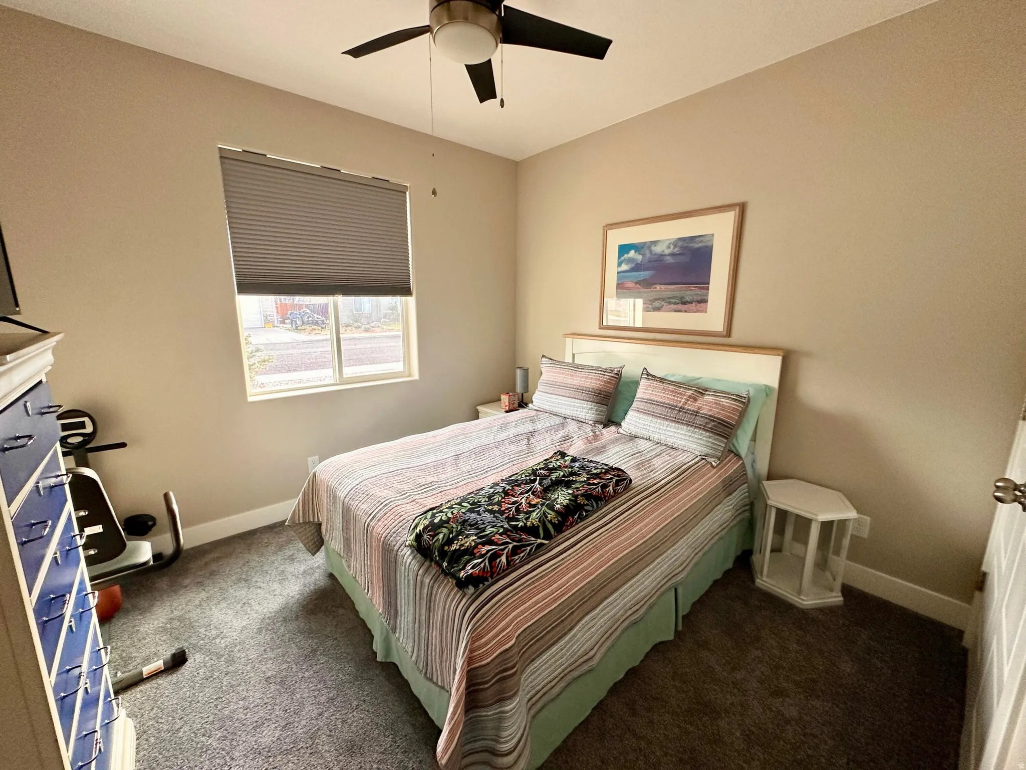 Carpeted bedroom featuring baseboards and ceiling fan