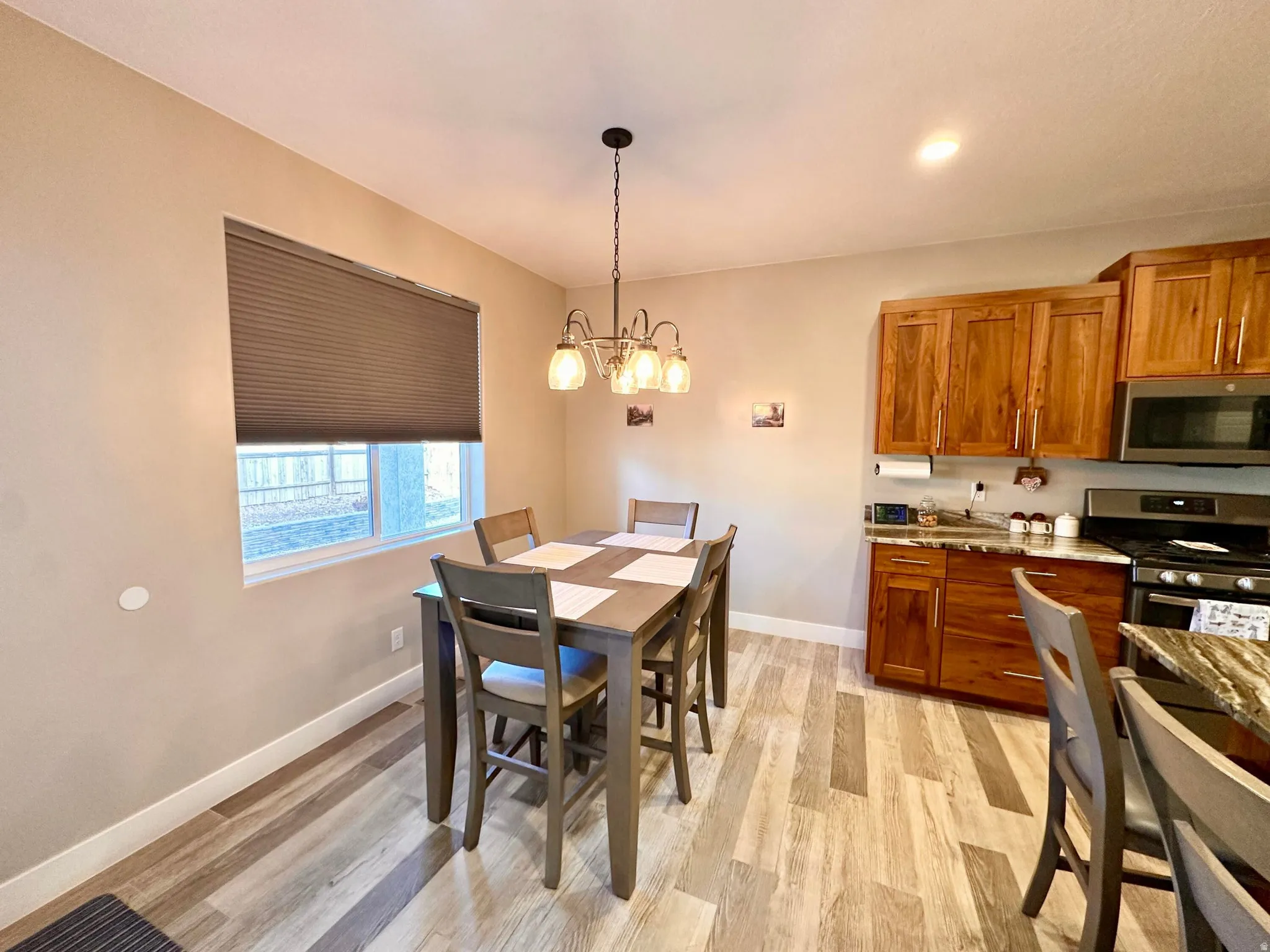 Dining room with light wood-style floors, recessed lighting, and a chandelier