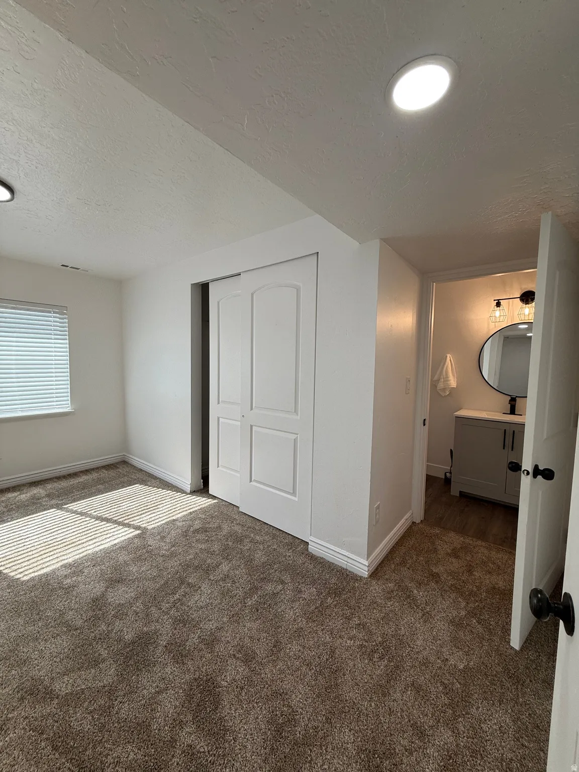 Unfurnished bedroom with carpet floors, a closet, a textured ceiling, and recessed lighting