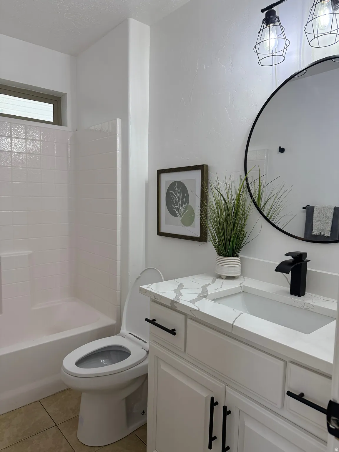 Full bathroom with vanity, light tile patterned floors, tub / shower combination, and a textured ceiling
