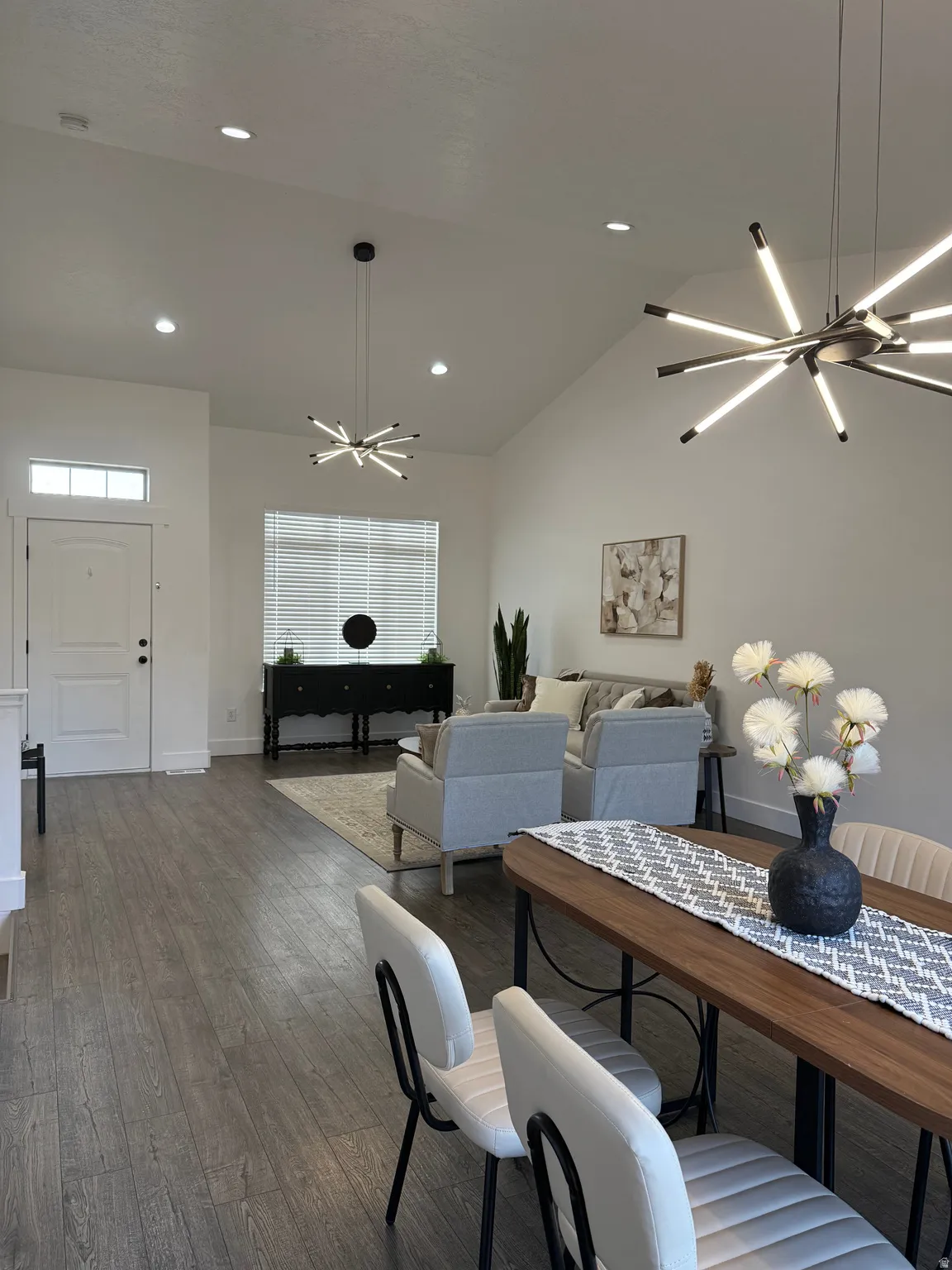 Dining space with a chandelier, vaulted ceiling, dark wood-style floors, and recessed lighting